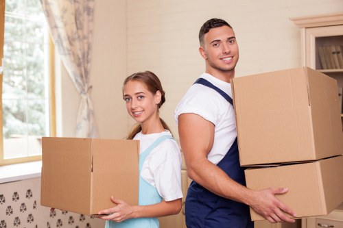 Packed moving boxes and furniture prepared for transport in Acton