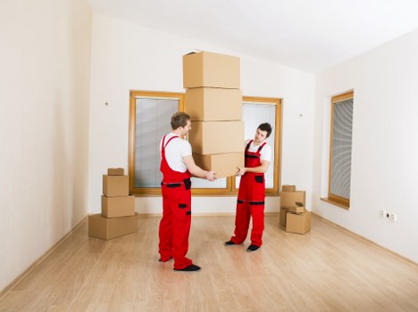 Mover wearing PPE while carrying furniture during an Acton removal